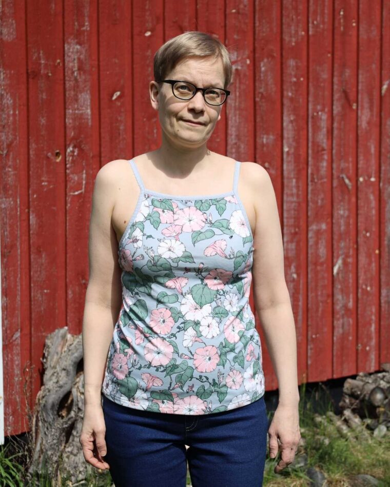 Woman standing in front of a barn wearing Liesl + Co Tribeca Knit Cami with fold over elastic