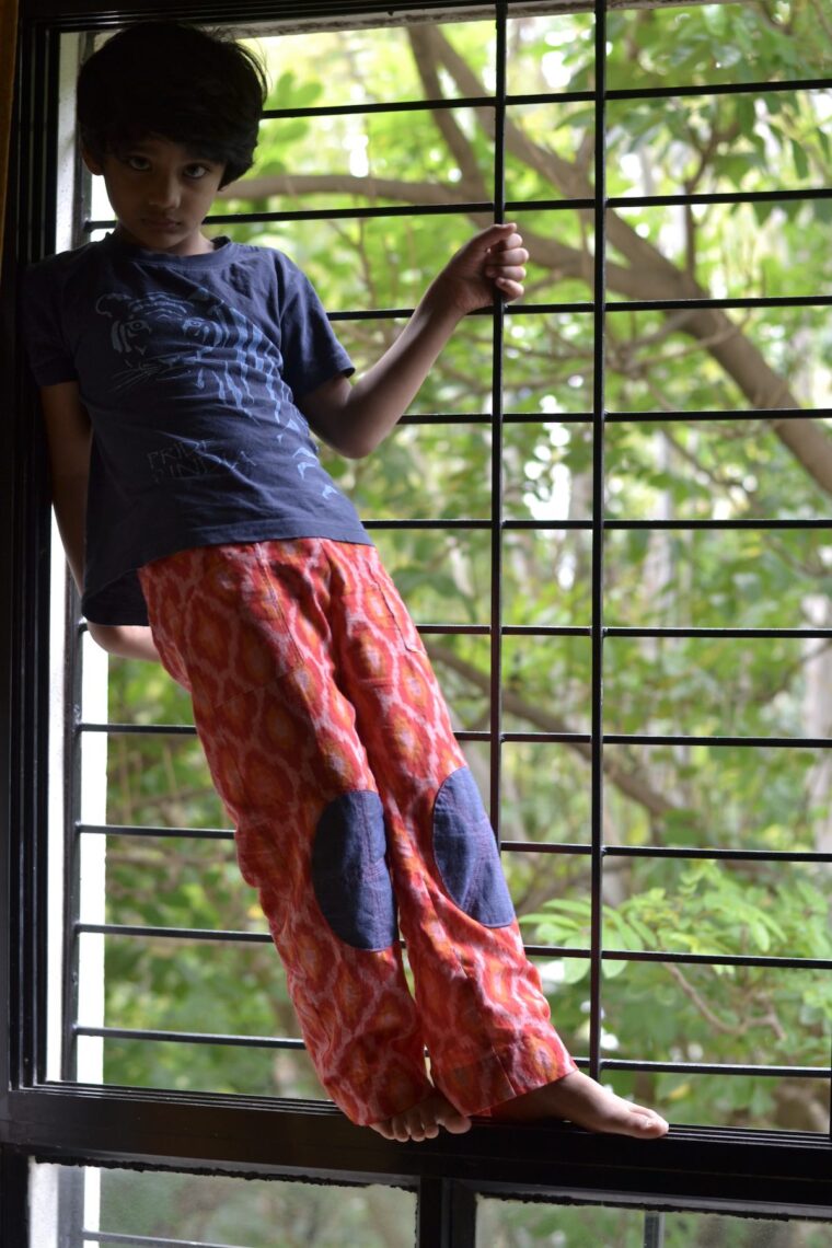 Boy wearing pants with visible mending on the knees