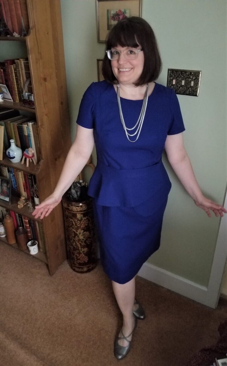 Woman wearing a blue Rush Hour dress with removal peplum 