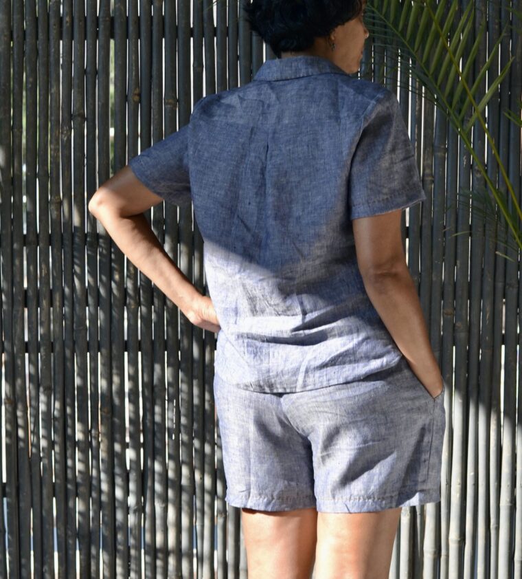 Back view of a woman wearing a button up pajama shirt and pajama shorts