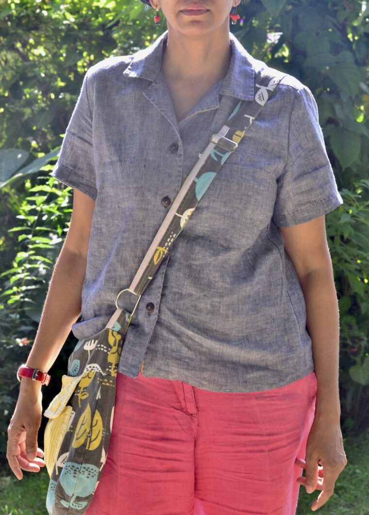 Woman standing outside wearing a button up pajama shirt with day shorts