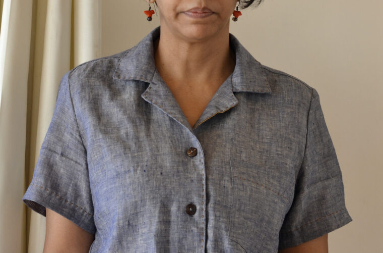 Close up of woman wearing a button down shirt, detailing running stitch embroidery