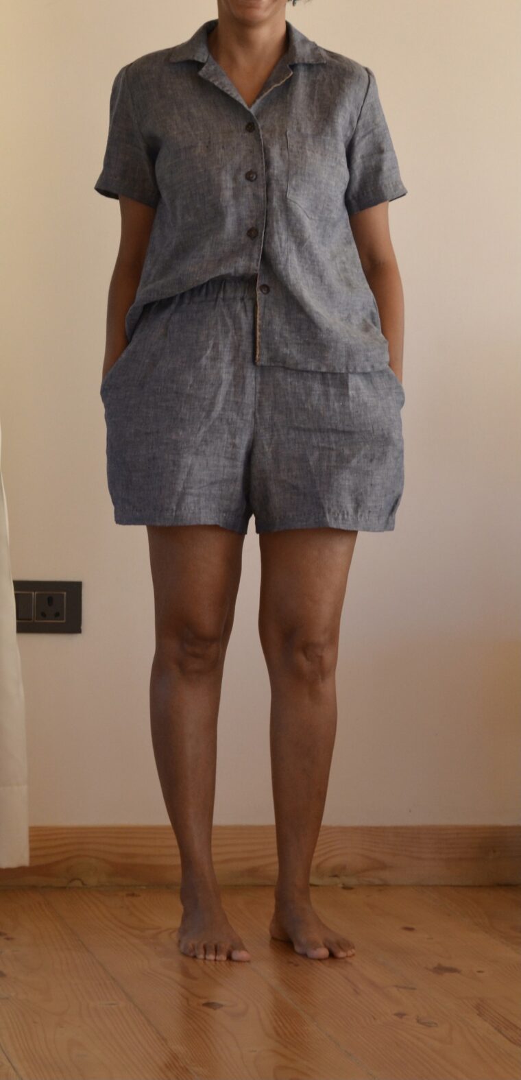 Close up of a woman wearing a button up pajama shirt and pajama shorts