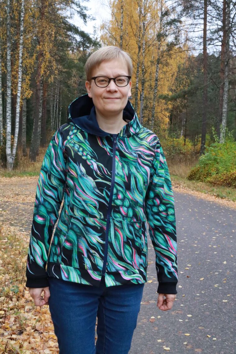 Front view of woman wearing a jacket in a colorful print.