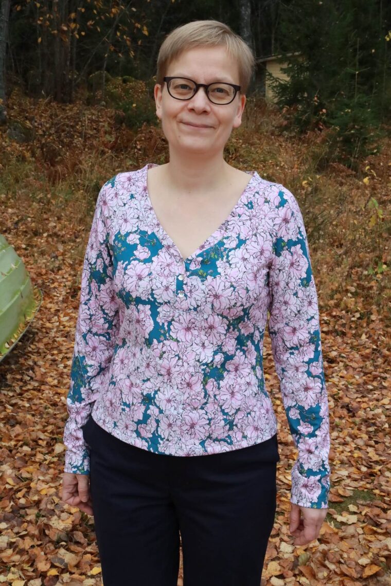 Woman wearing henley knit shirt in a print jersey fabric, layered over a cami