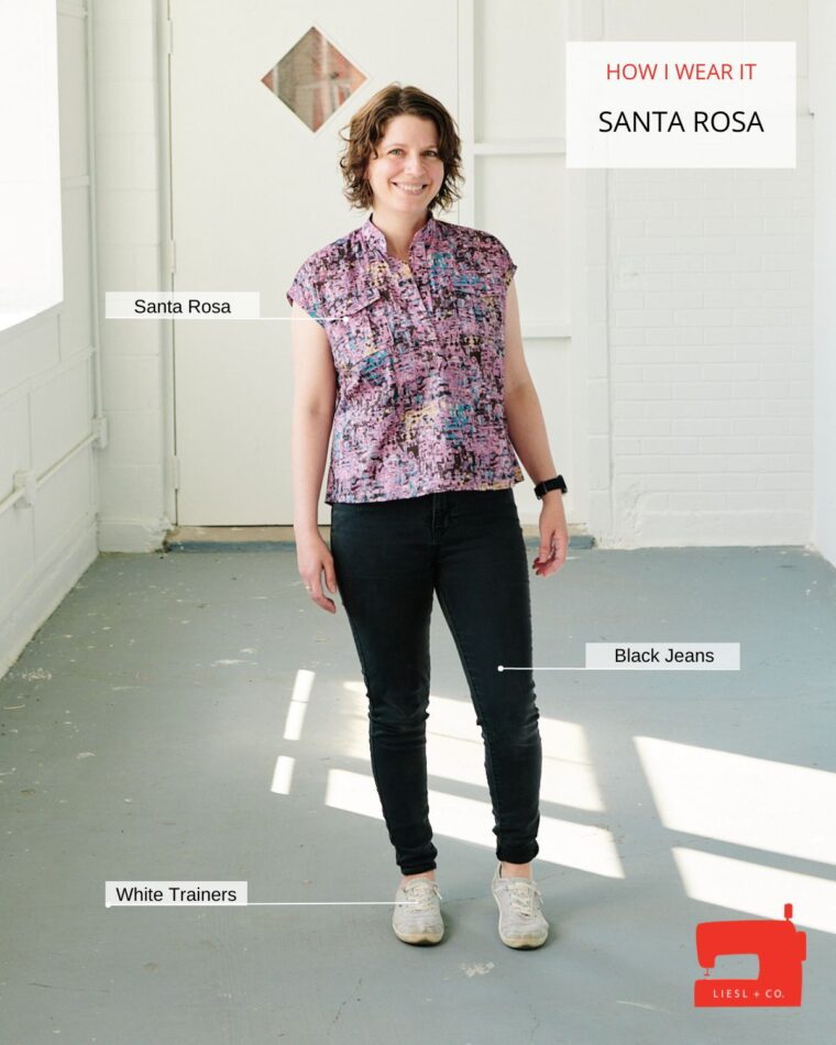 Woman standing in hallway wearing a pink Santa Rosa Top and black jeans. The text on the image says "How I Wear It: Santa Rosa". There is additional text labeling each piece she is wearing.