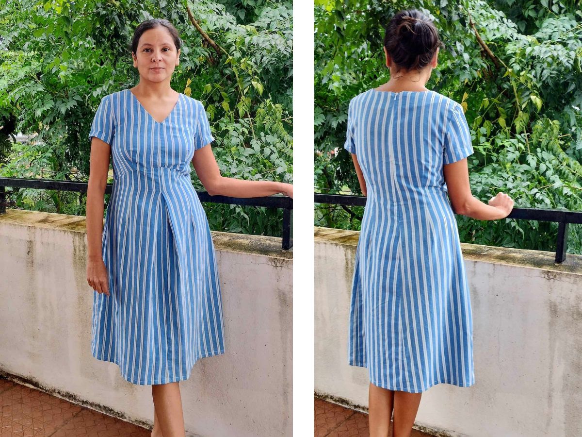 front and back views of a woman wearing a short-sleeve, v-neck blue cotton dress with white stripes.