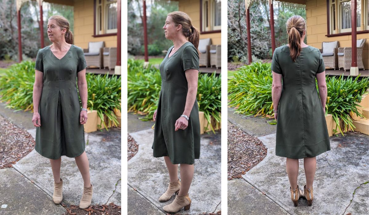 Front, side and back views of a white woman wearing a short-sleeve, v-neck dress with a fitted bodice and front inverted box pleat.