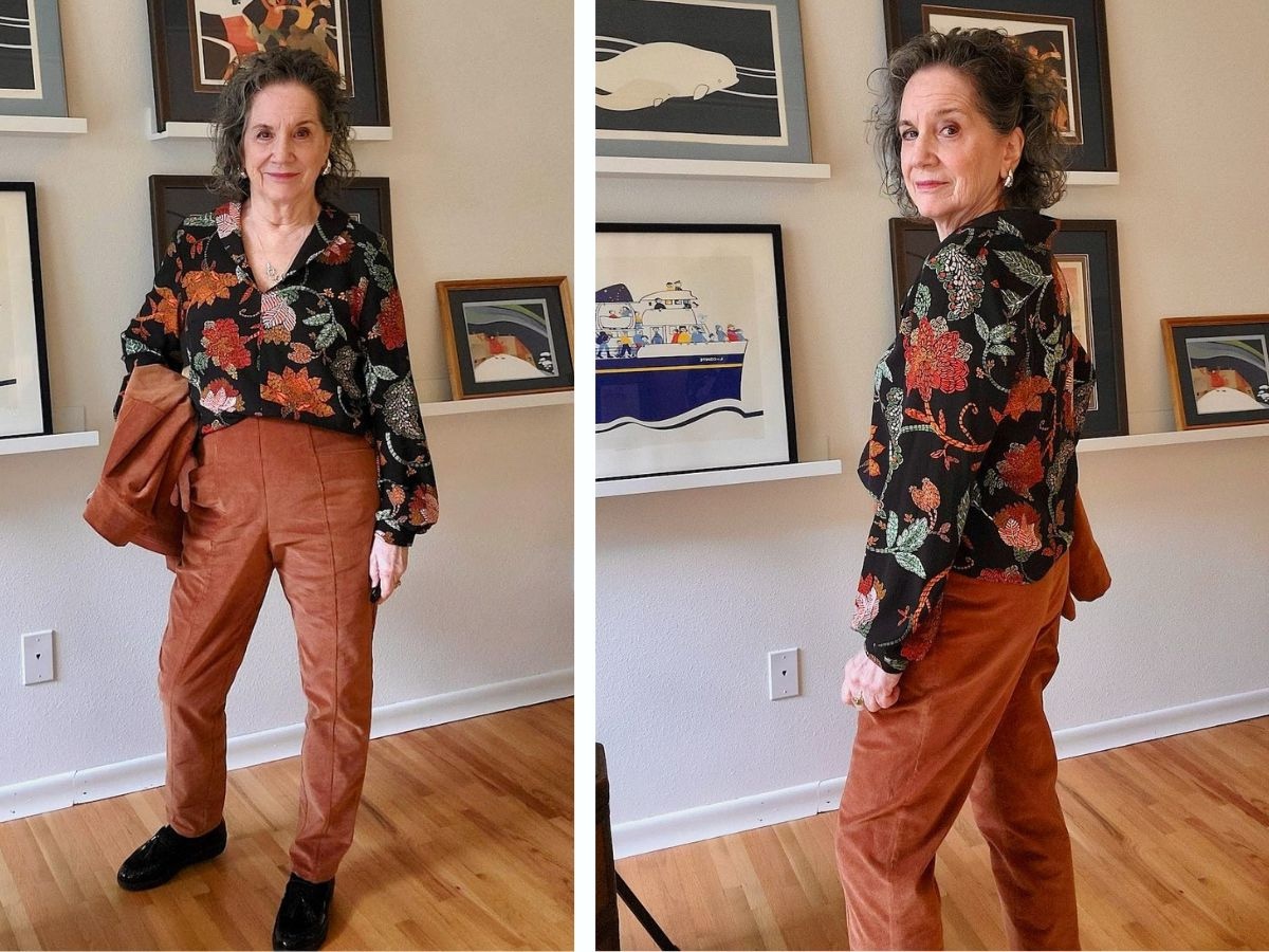 woman wearing long sleeve, shawl color, black floral patterned shirt with brown pants